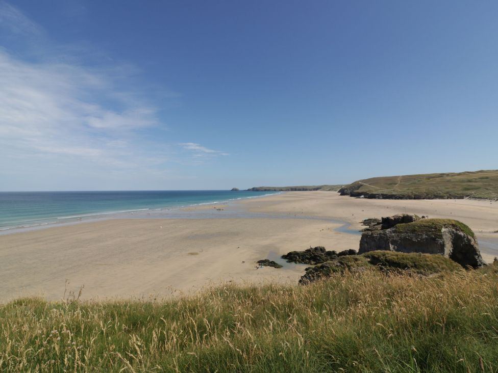 A beach with sand and ocean at Greenways in Perranporth
