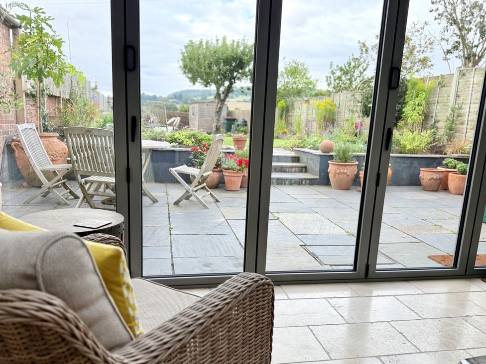 A conservatory overlooking a garden at The Garden Retreat in Winchcombe