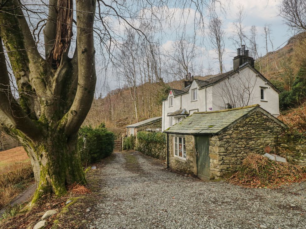 A house with a stone wall and tree in front at Brockstones in Grasmere
