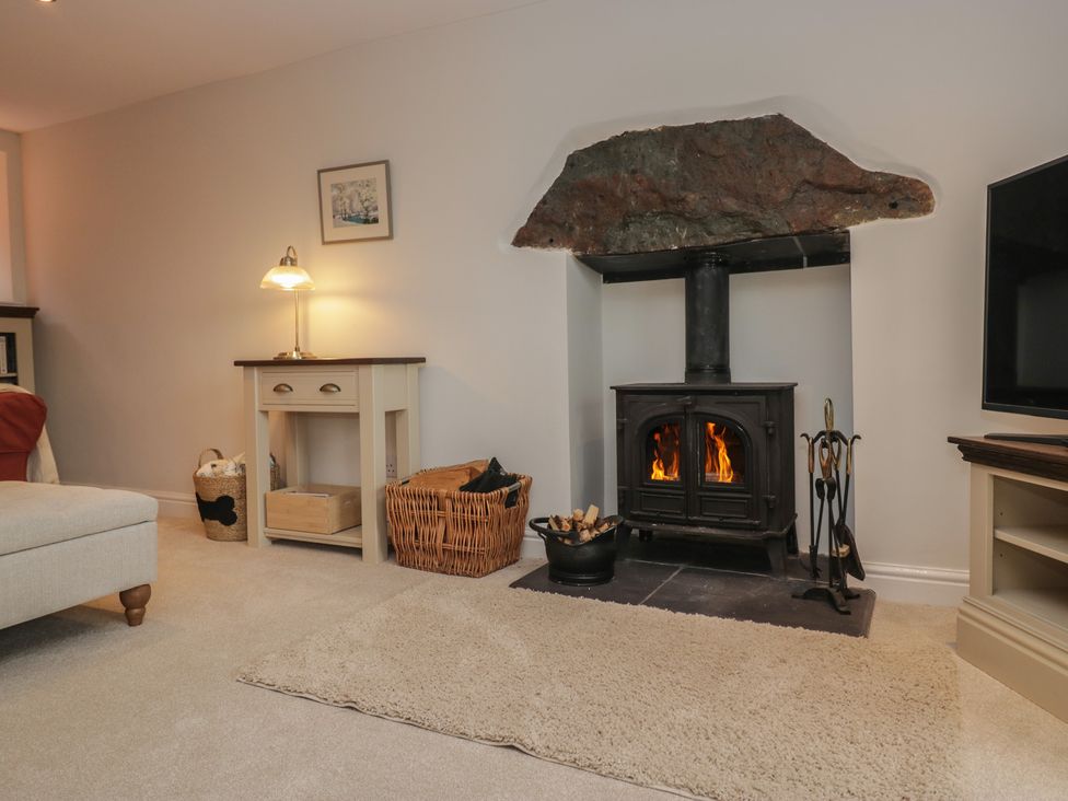 A living room with a wood stove and side table at Brockstones Grasmere