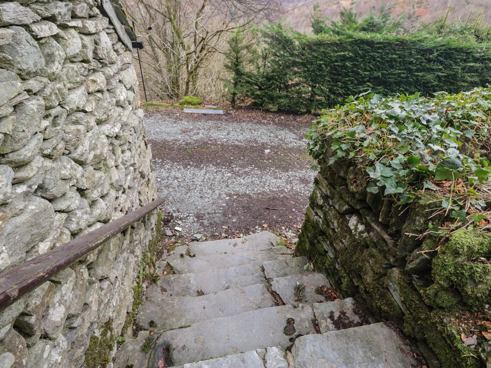 A staircase leading down with stone walls and gravel path at Brockstones Grasmere