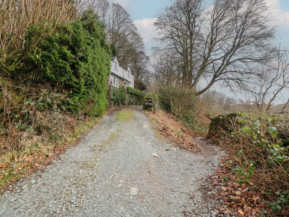 A gravel path leading to a house surrounded by trees and bushes at Brockstones in Grasmere