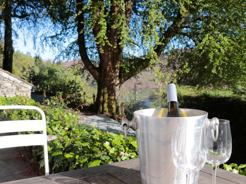 An outdoor setting with a wine bottle in an ice bucket and glasses at Brockstone in Grasmere