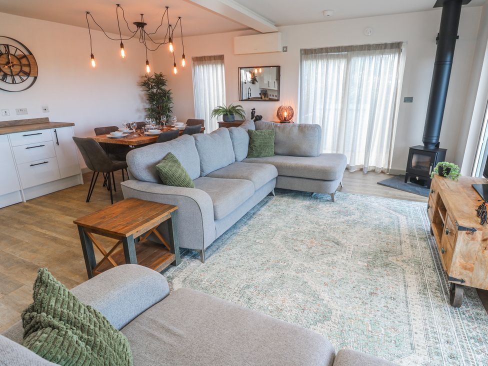 A living room with a sofa and dining area at Bay View in Portreath