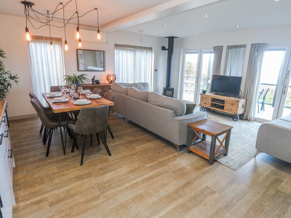 A living room with a dining area and television at Bay View in Portreath