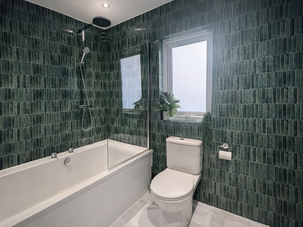A bathroom with a bathtub and shower at Bay View in Portreath