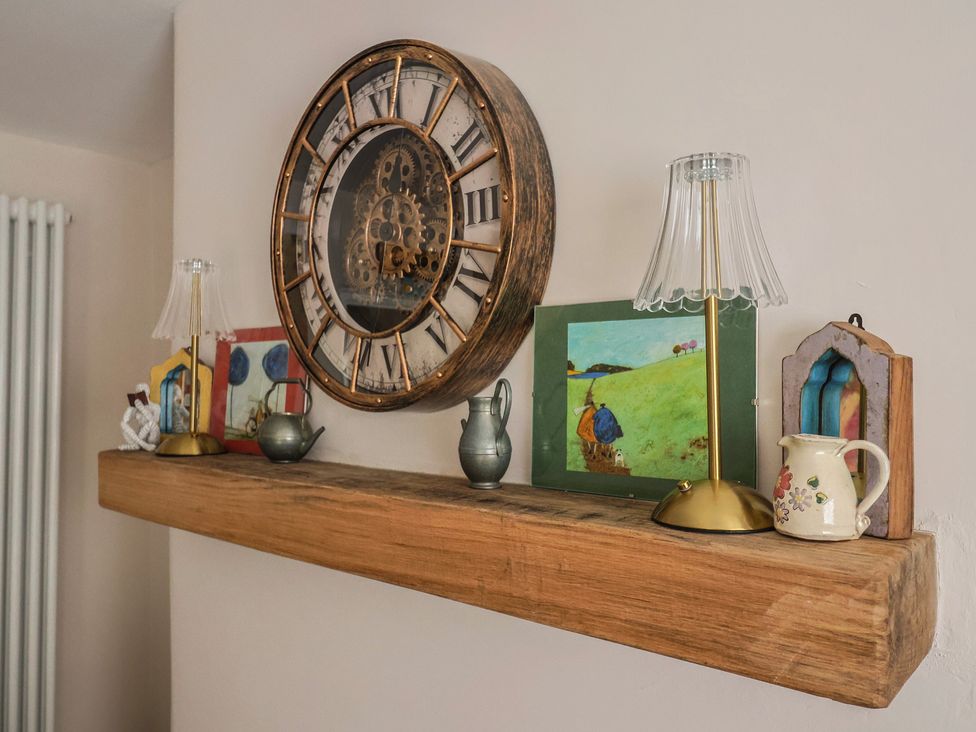 A wooden shelf with a clock, lamp, and decorative items at 6 Bedford Place in Bridport