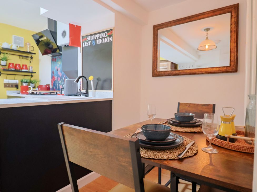 A dining room with a table set for meals at 6 Bedford Place in Bridport