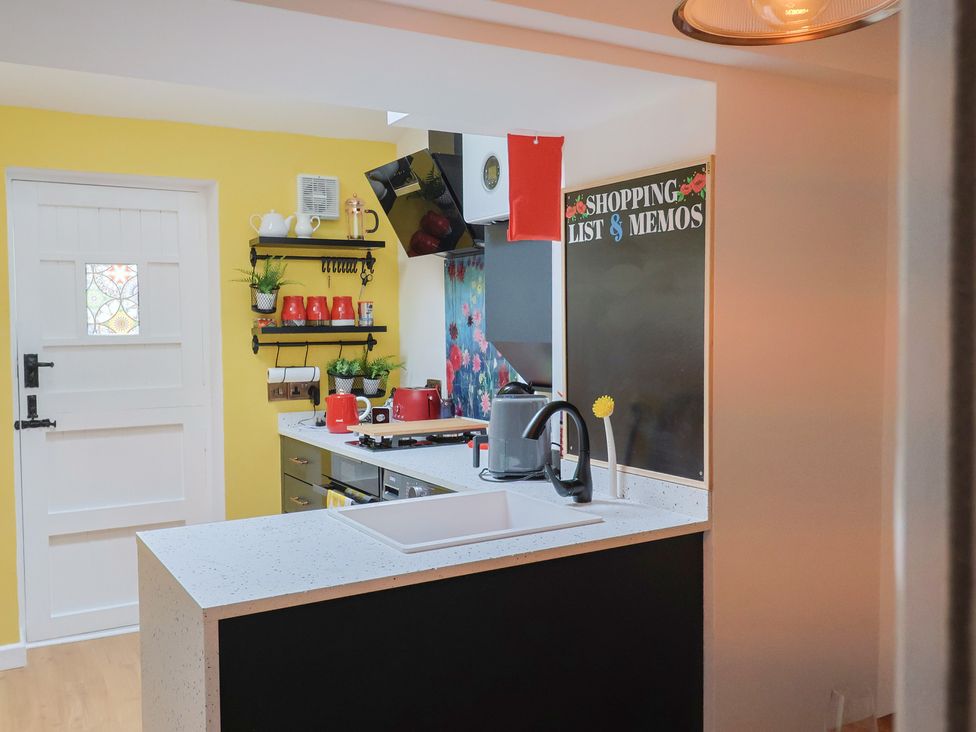 A kitchen with a kettle and red cups at 6 Bedford Place in Bridport