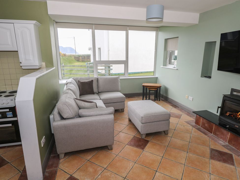 A living room with a couch and ottoman at No.3 Beach Cottages in Keel, County Mayo