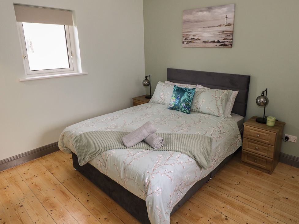 A bedroom with a bed and nightstand at No.3 Beach Cottages, Keel, County Mayo
