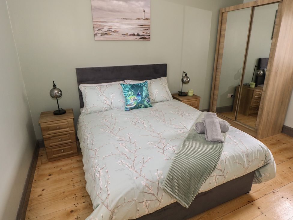 A bedroom with a bed and nightstands at No.3 Beach Cottages in Keel, County Mayo