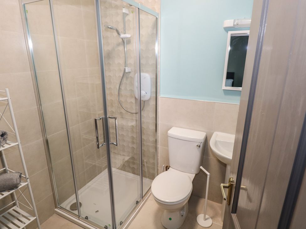 A bathroom with a shower, toilet, and sink at No.3 Beach Cottages, Keel, County Mayo
