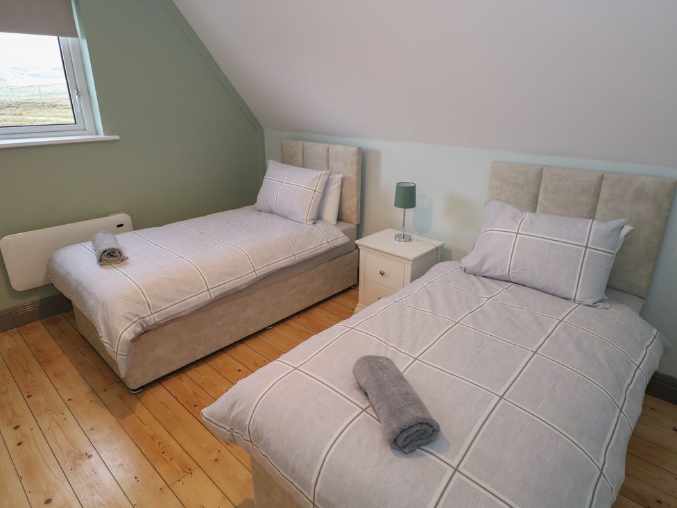 A bedroom with two single beds and a nightstand at No.3 Beach Cottages, Keel, County Mayo