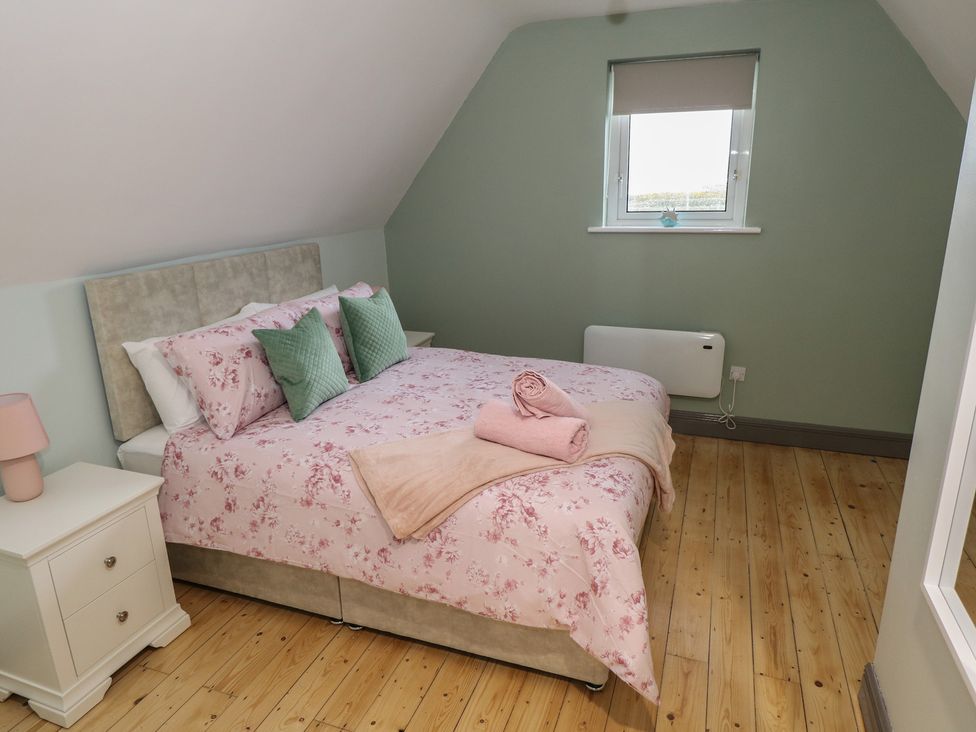 A bedroom with a bed and nightstand at No.3 Beach Cottages in Keel, County Mayo