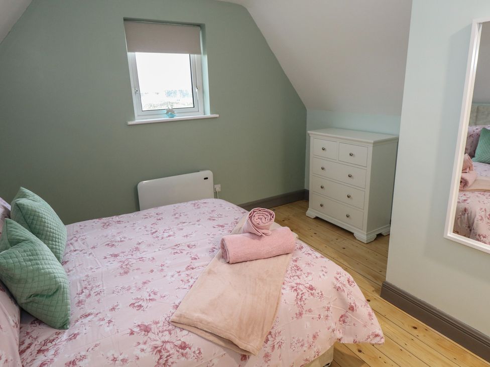 A bedroom with a bed and dresser at No.3 Beach Cottages, Keel, County Mayo