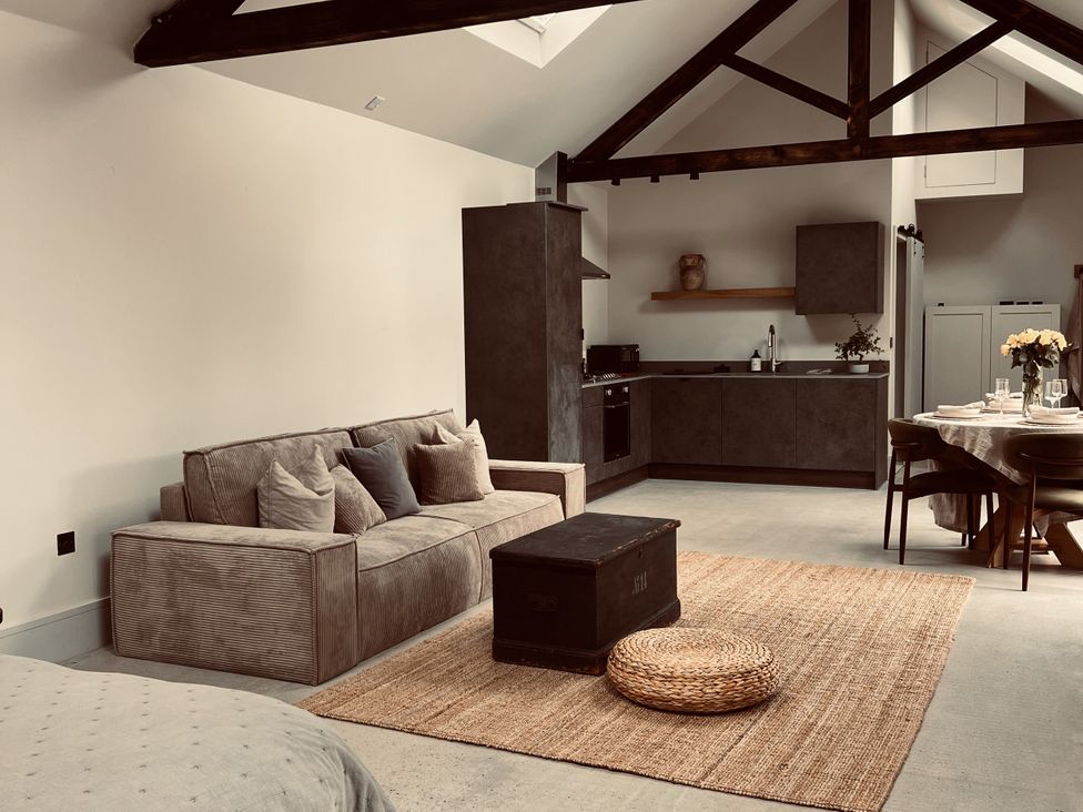 A living room with a sofa and kitchen area at Wabi in Gembling near Beeford
