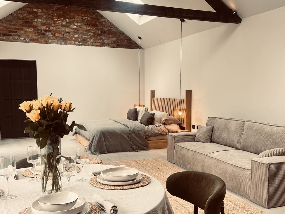 A bedroom with a bed and seating area at Wabi Gembling near Beeford