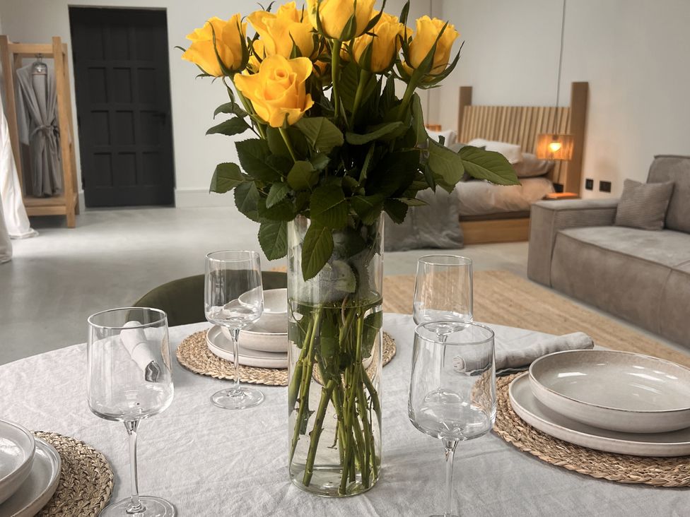 A dining table with yellow roses and wine glasses at Wabi Gembling near Beeford