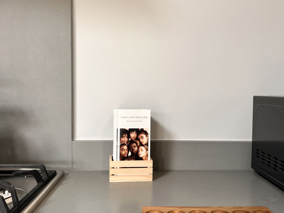 A kitchen countertop with a book on a wooden stand and a gas stove at Wabi in Gembling near Beeford