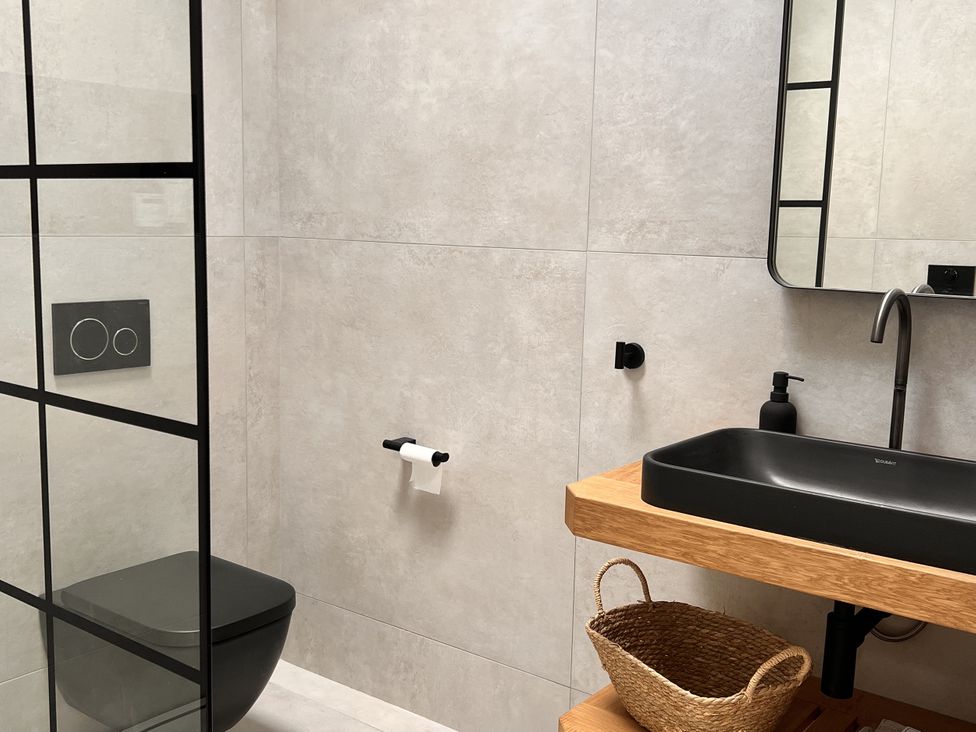 A bathroom with a black toilet and wash basin at Wabi in Gembling near Beeford