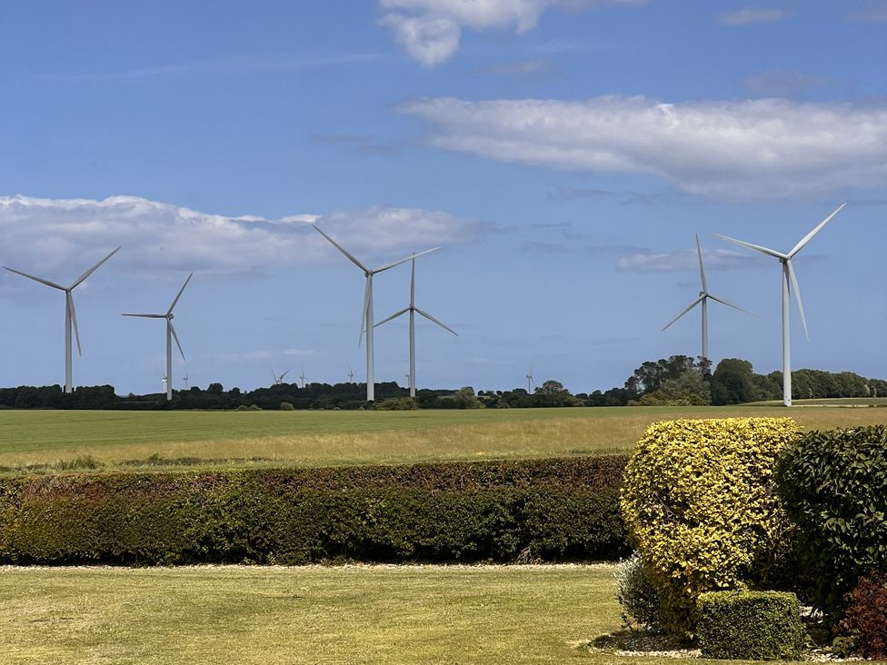 A field with wind turbines in the distance at Wabi in Gembling near Beeford