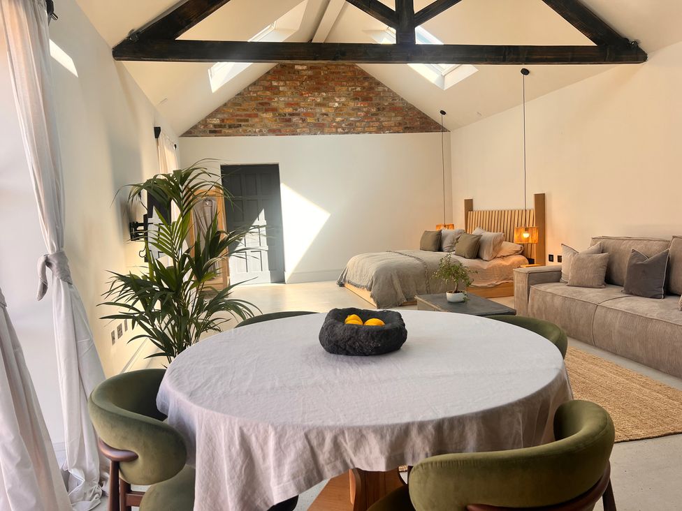 A living room with a table and chairs and a bed at Wabi in Gembling near Beeford
