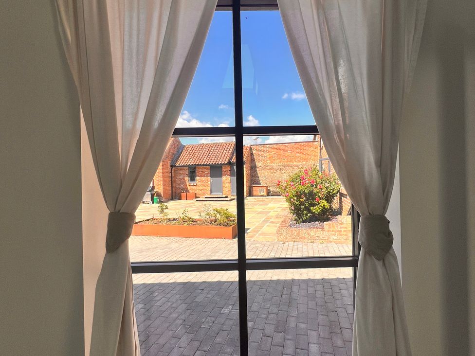 A view of an outdoor space through a window with curtains at Wabi in Gembling near Beeford