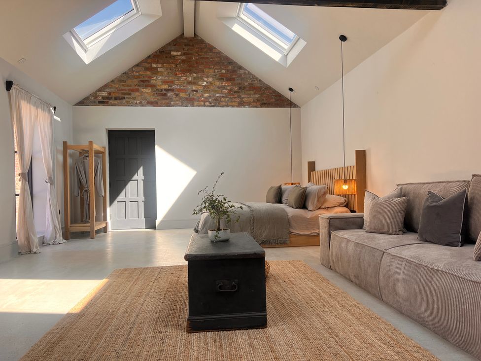 A bedroom with a bed and sofa at Wabi in Gembling near Beeford