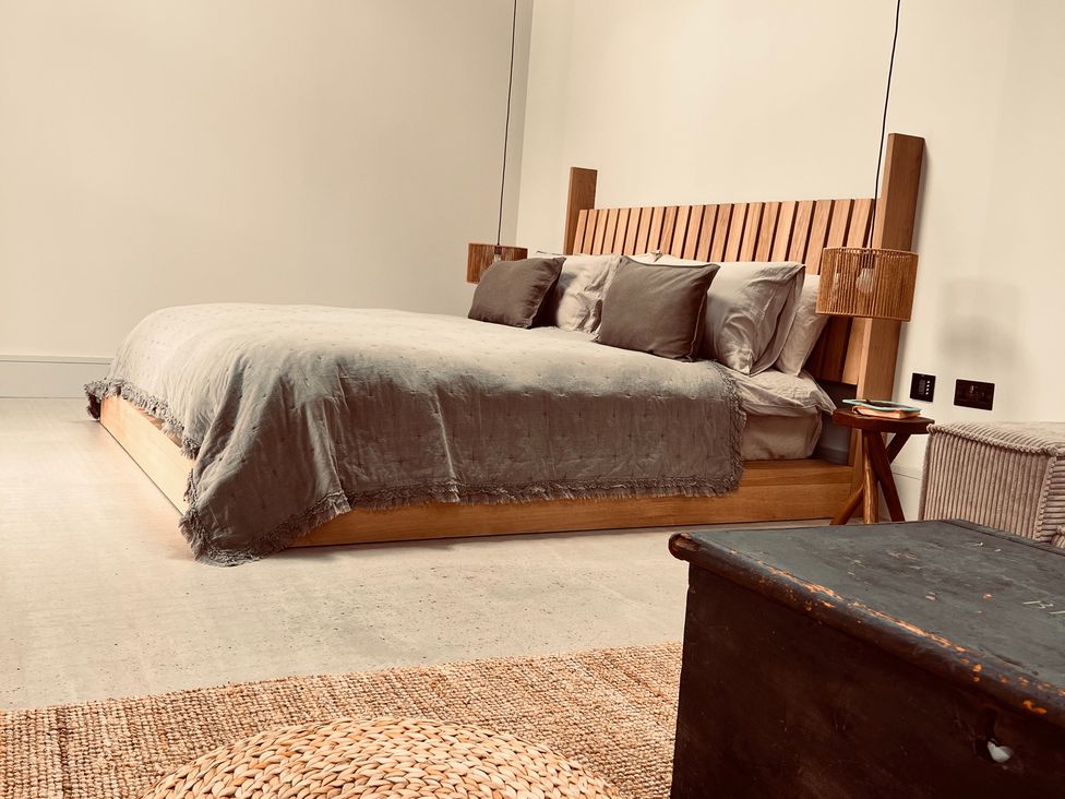 A bedroom featuring a bed with bedding and lamps at Wabi Gembling near Beeford
