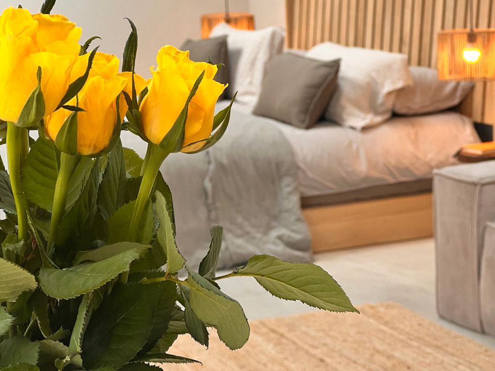 A bedroom with yellow roses on a table at Wabi in Gembling near Beeford