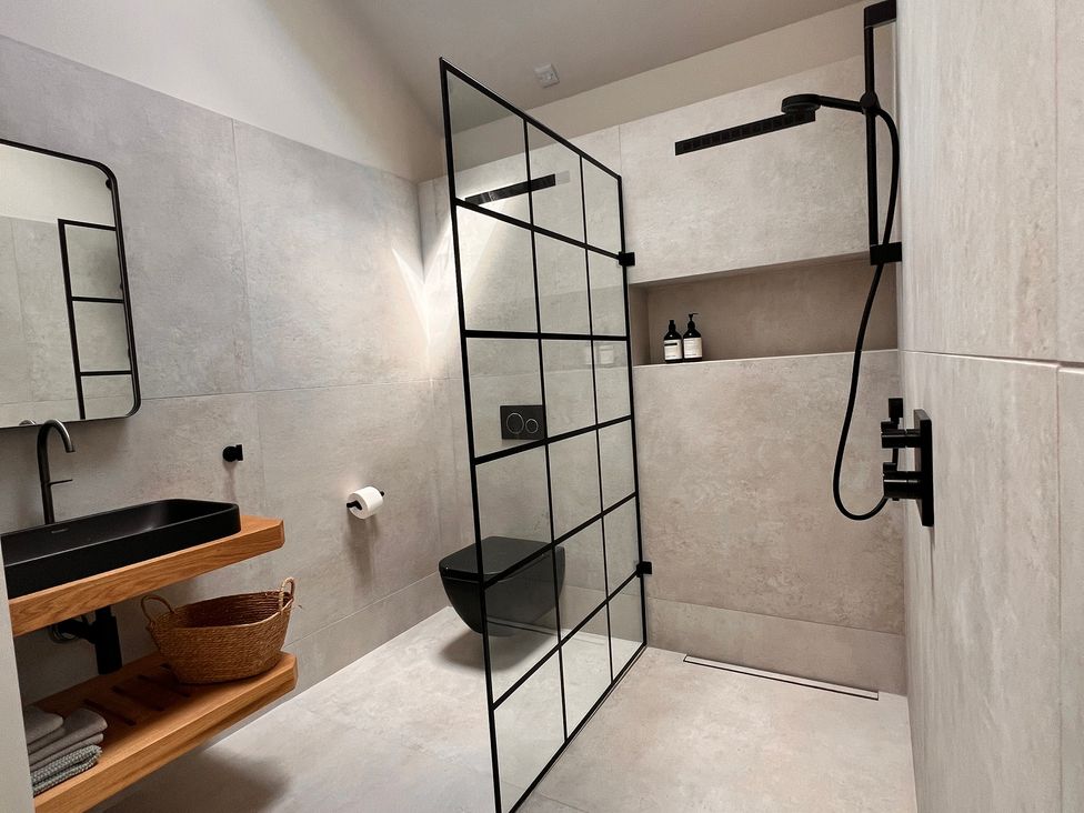A bathroom featuring a sink, shower, toilet, and storage at Wabi in Gembling near Beeford