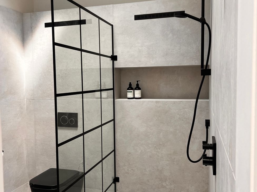 A bathroom with a shower, toilet, and shelf at Wabi in Gembling near Beeford