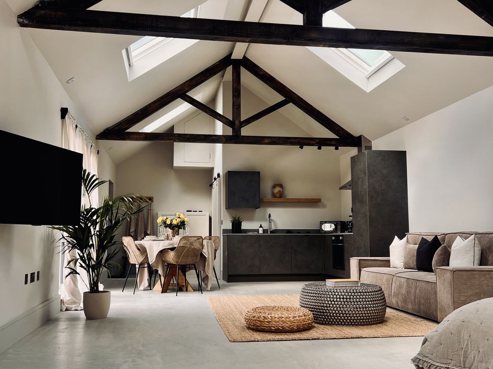 A living room with a sofa and dining area at Sabi in Gembling near Beeford