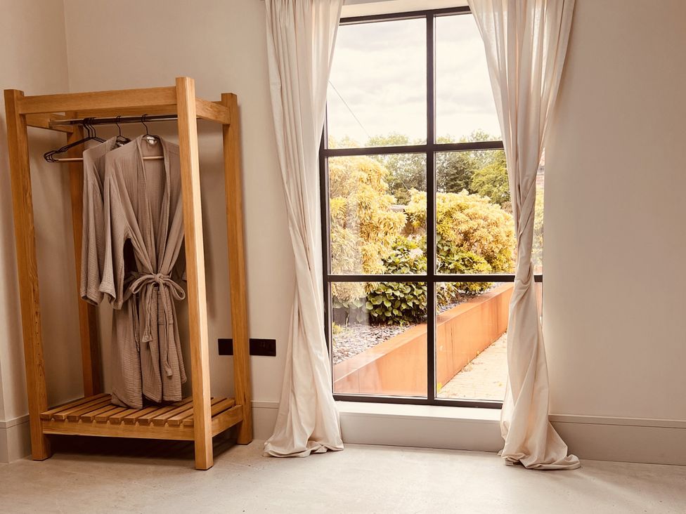 A bathroom with a robe hanging by a window at Sabi in Gembling near Beeford