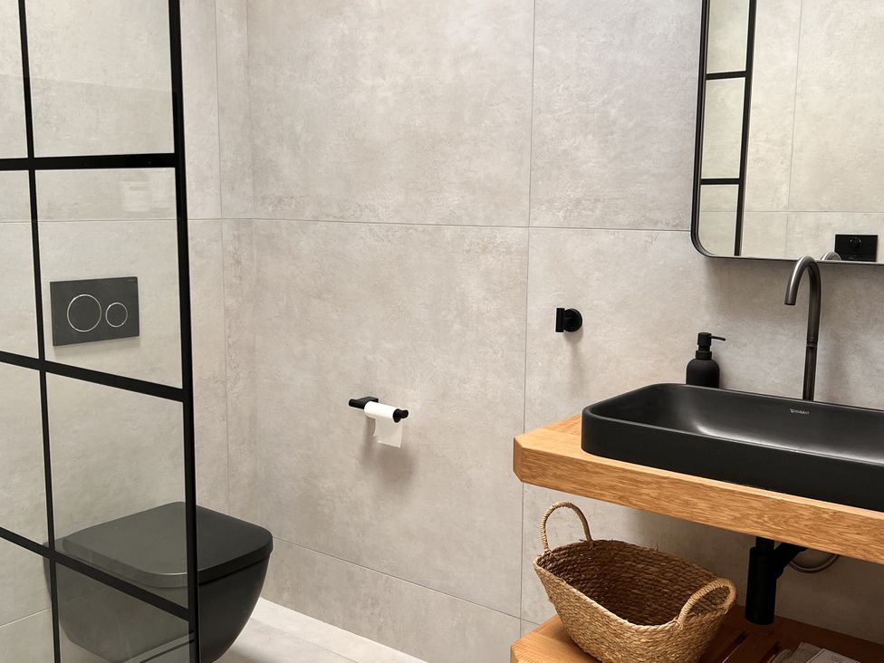 A bathroom with a black toilet and sink and a mirror at Sabi in Gembling near Beeford