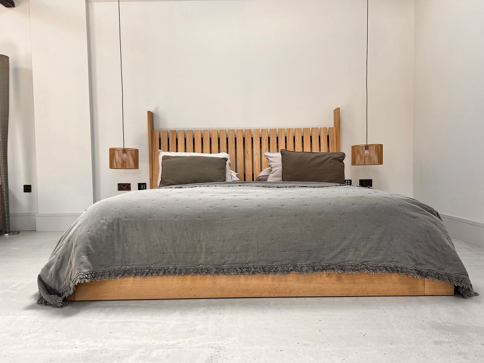 A bedroom with a bed and hanging light fixtures at Sabi Gembling near Beeford