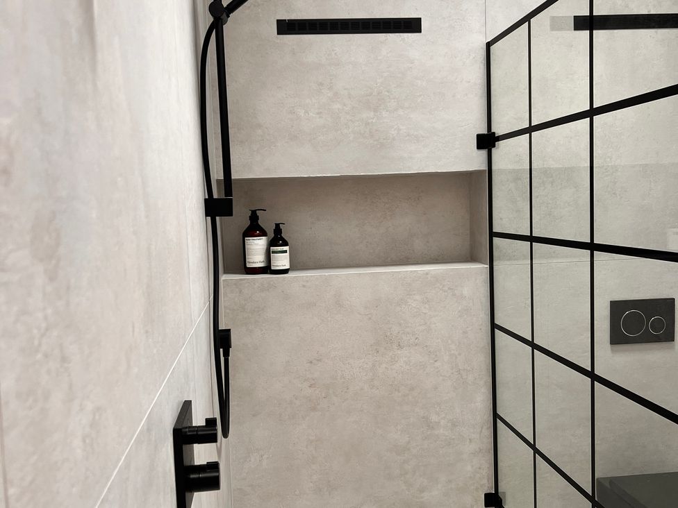 A shower area with shelving and soap dispensers at Sabi Gembling near Beeford