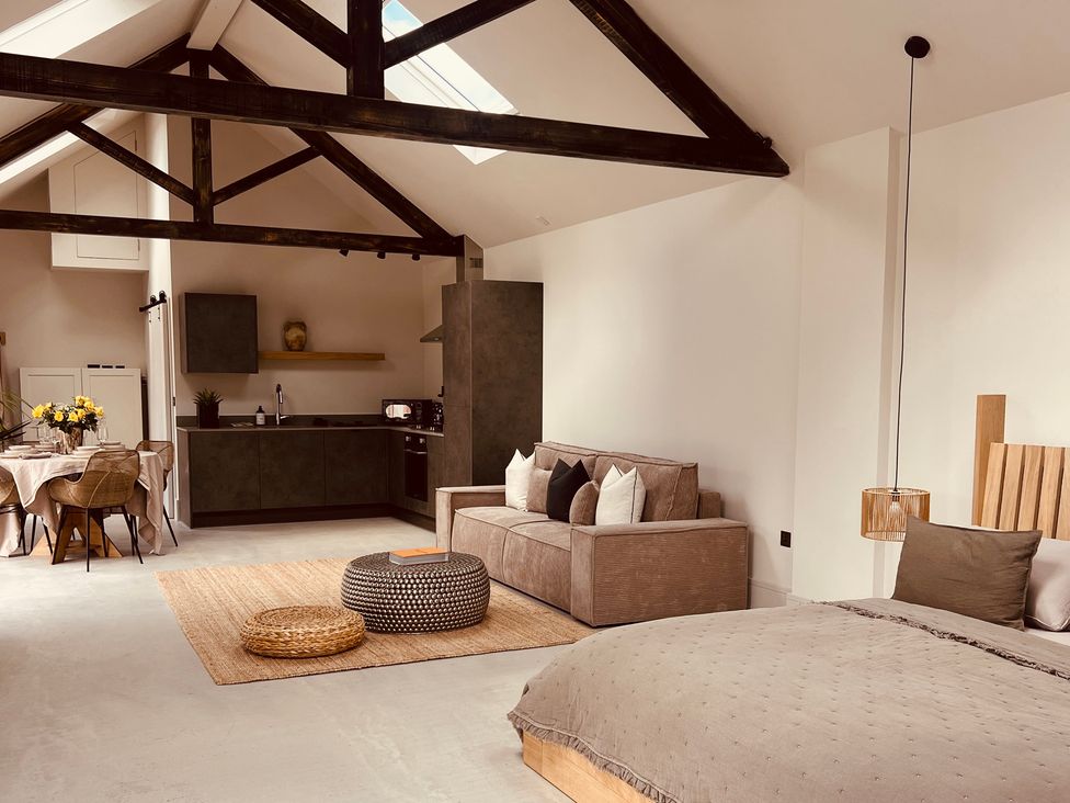 An open plan living area with a sofa, kitchen and bed at Sabi in Gembling near Beeford