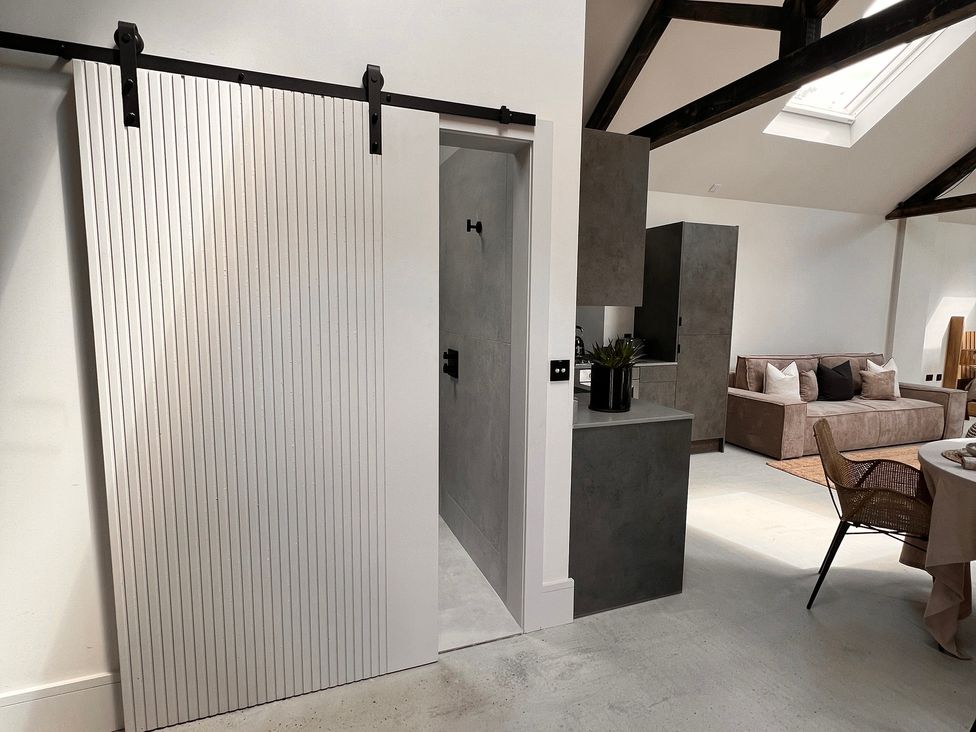 A living room with a sliding door and kitchen cabinet at Sabi in Gembling near Beeford