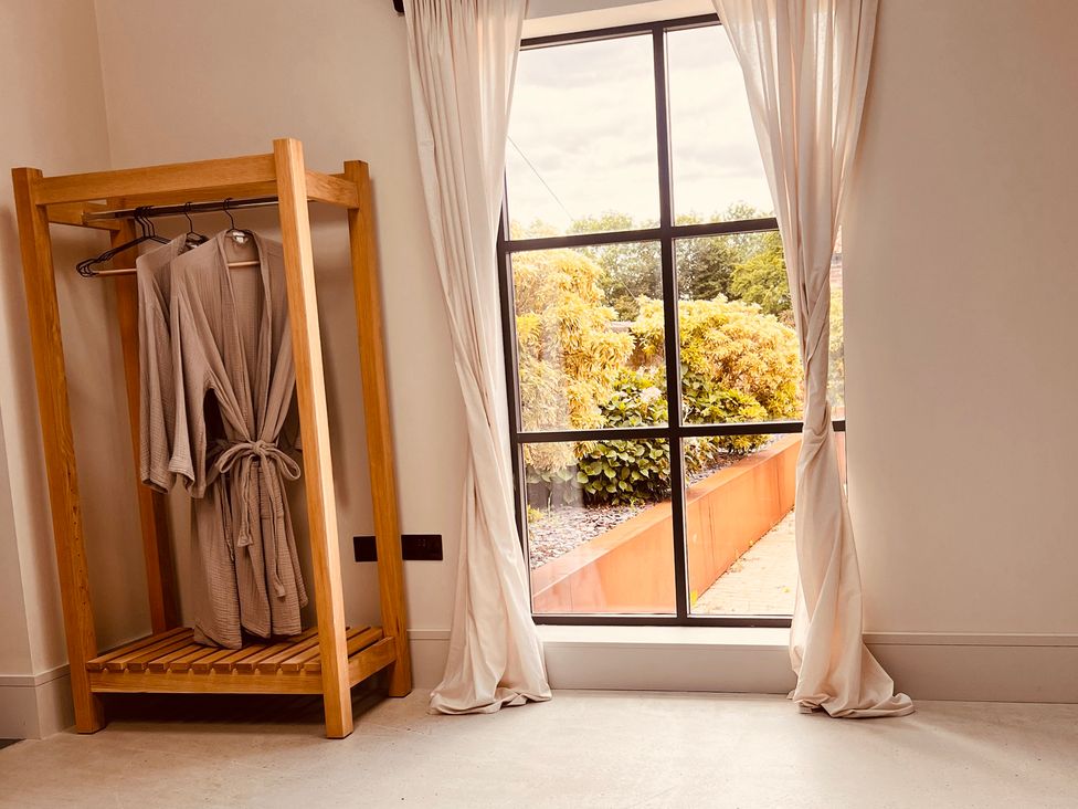 A bathroom with a clothes rack and robes at Sabi in Gembling near Beeford