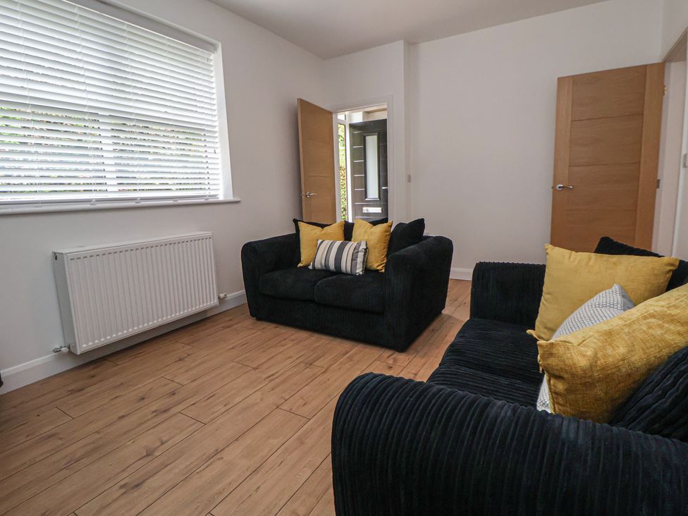 A living room with a sofa and cushions at 5 Marsh Lane in Flint