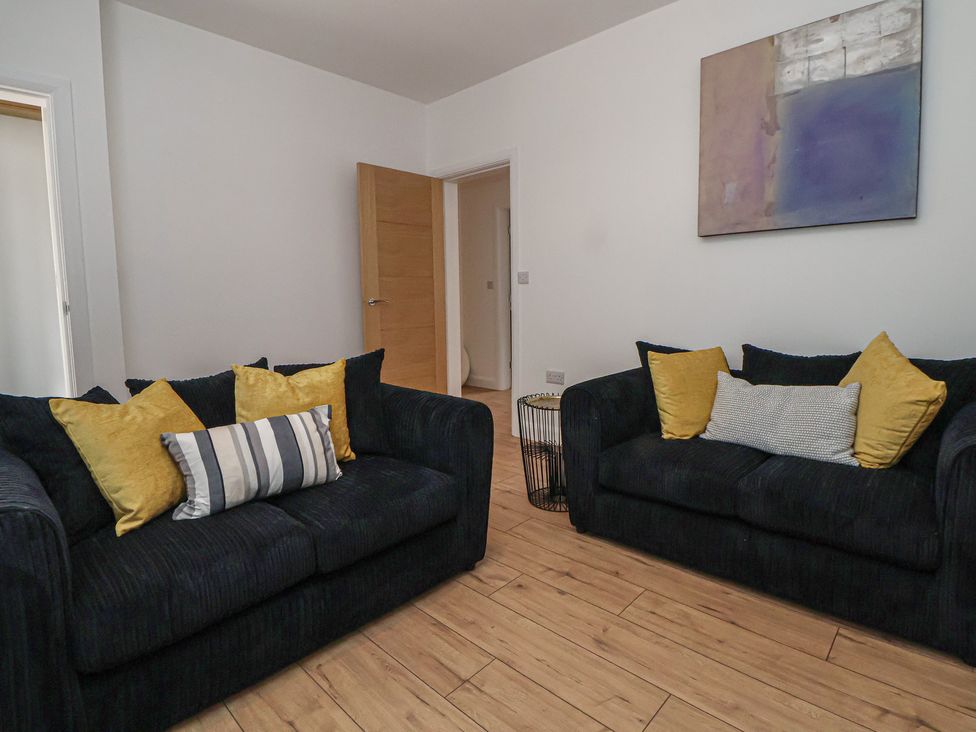A living room with two sofas and a door at 5 Marsh Lane Flint