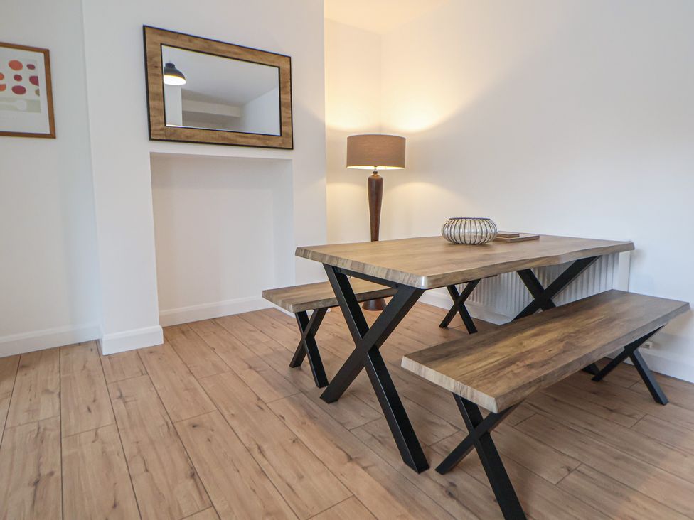 A dining table with benches and a lamp at 5 Marsh Lane Flint
