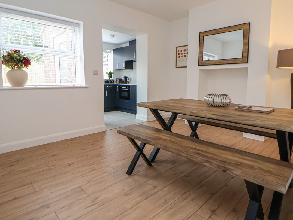 A dining area with a table and benches at 5 Marsh Lane Flint
