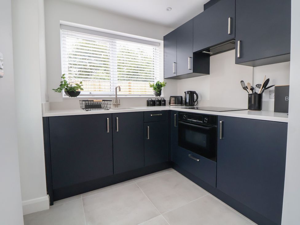 A kitchen with dark cabinets and countertops at 5 Marsh Lane in Flint