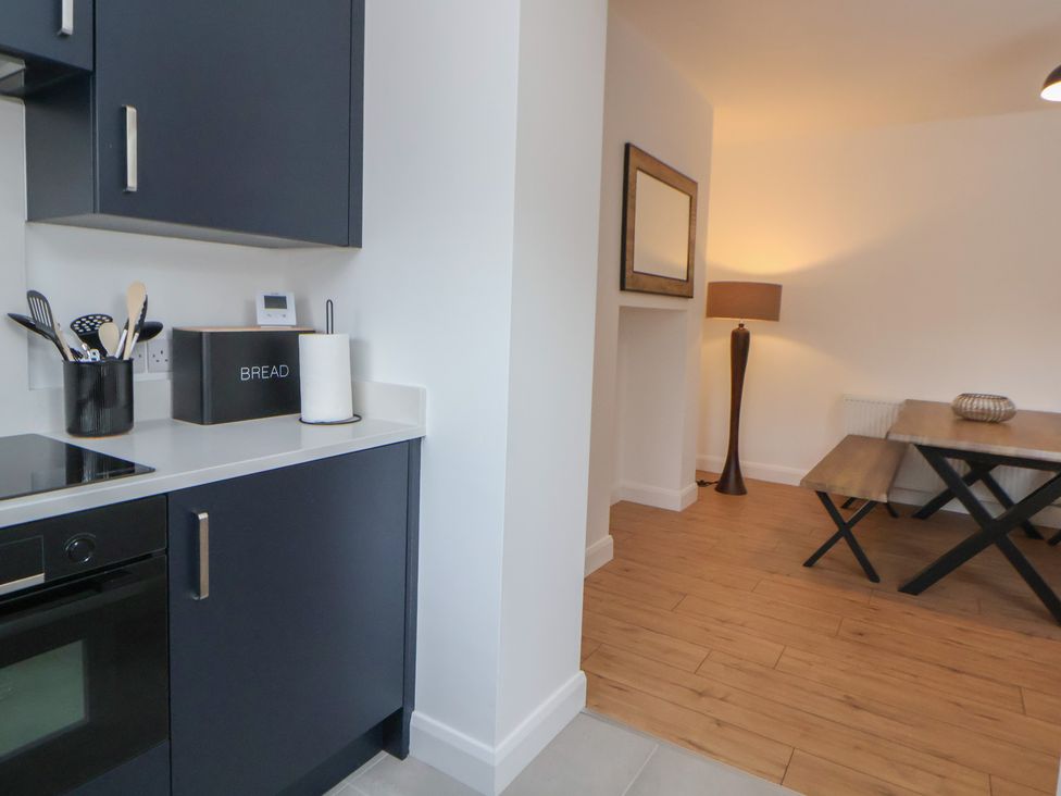 A kitchen with a stove and dining area at 5 Marsh Lane in Flint