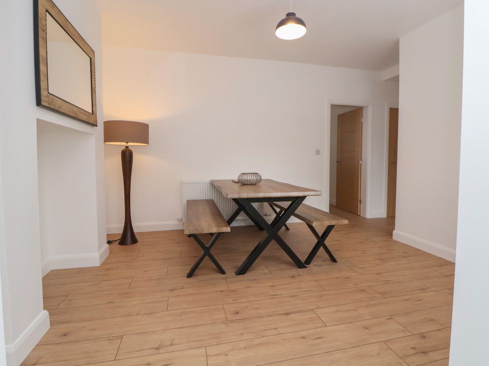 A dining room with a table and a lamp at 5 Marsh Lane in Flint