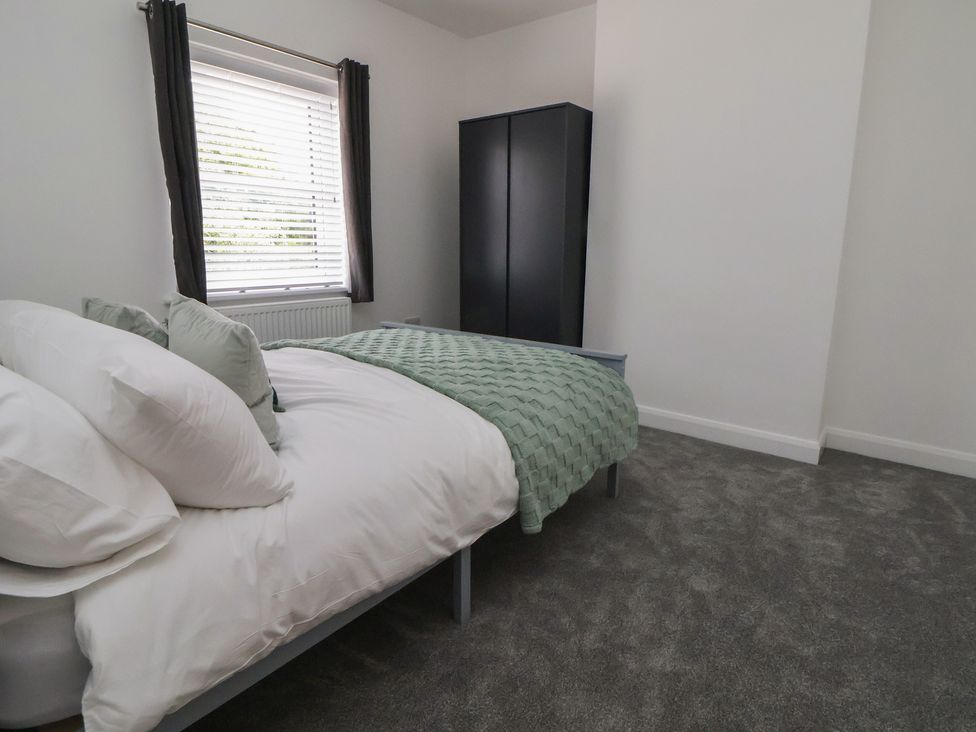 A bedroom with a bed and wardrobe at 5 Marsh Lane in Flint