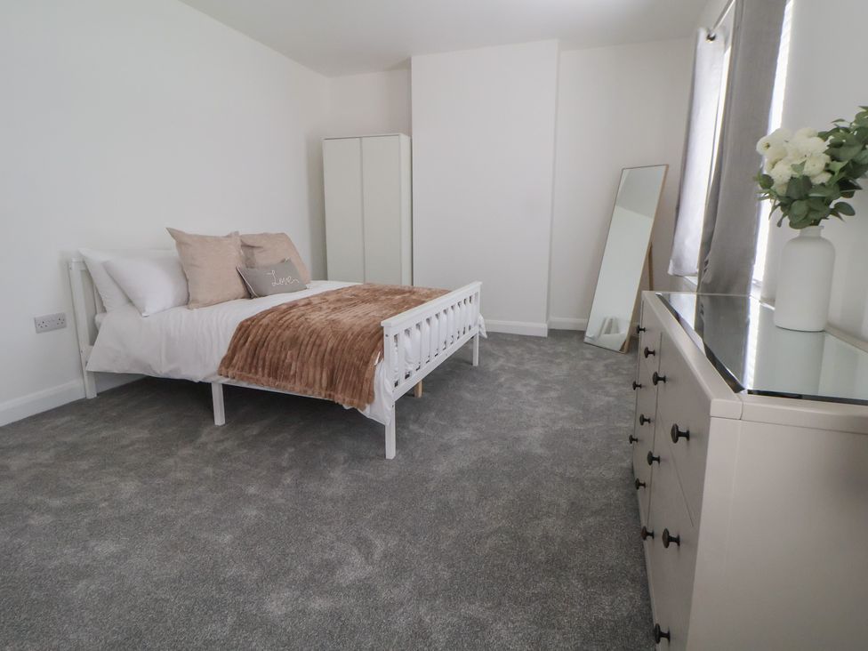 A bedroom with a bed, wardrobe, and dresser at 5 Marsh Lane, Flint